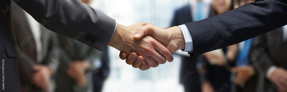 Obraz premium close-up of a handshake of business partners against the background of colleagues