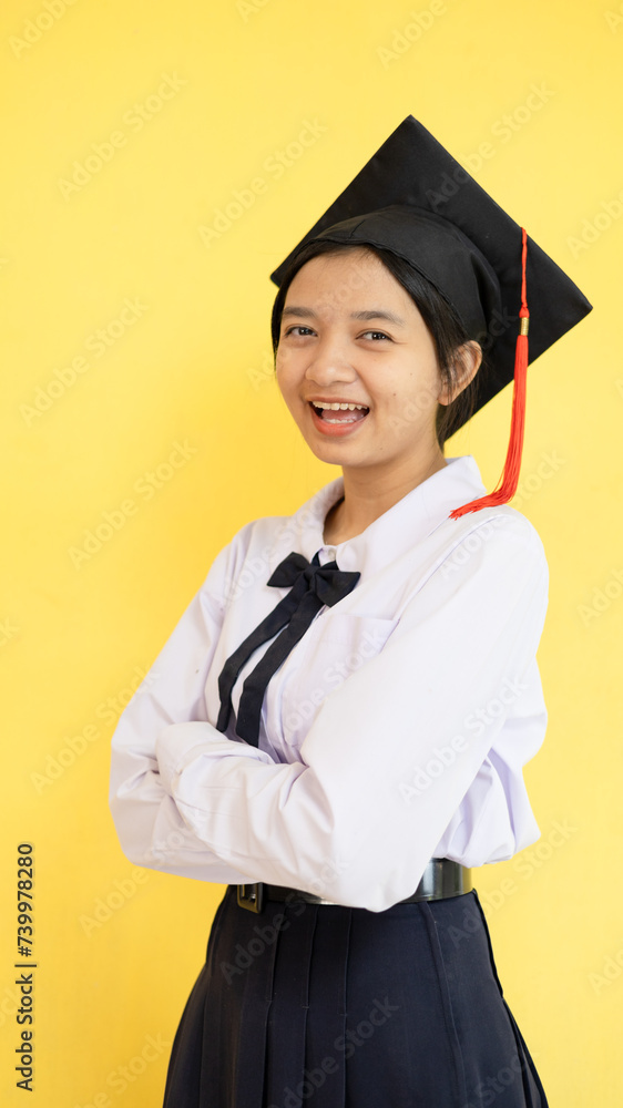 Happy student young girl wear Graduation hat on yellow background. Happy student young girl wear Graduation hat on yellow background.