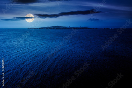 Fototapeta Naklejka Na Ścianę i Meble -  seascape with island at night. rippled water surface in full moon light