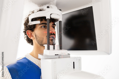 Man undergoing dental panoramic x-ray in clinic photo