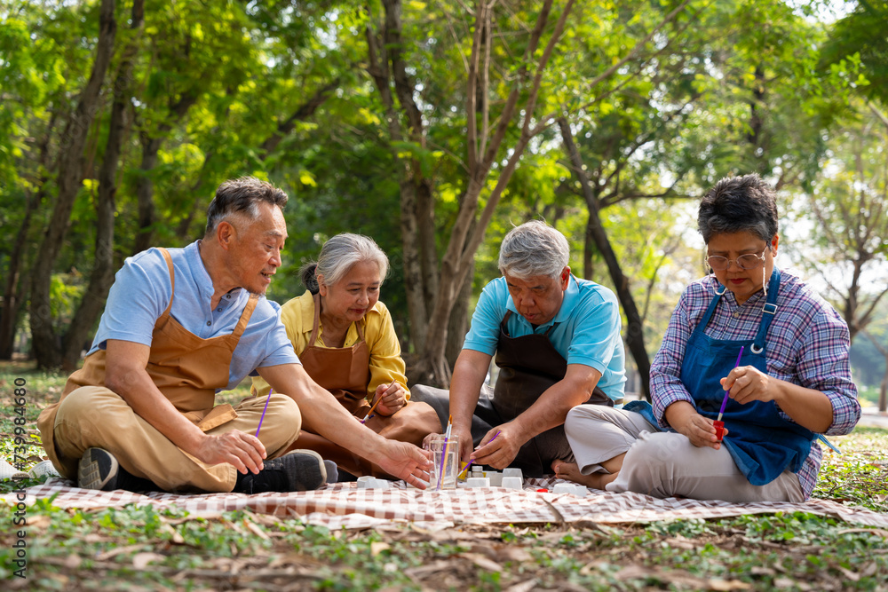 Fototapeta premium A group of Asian senior people enjoy painting cactus pots and recreational activity or therapy outdoors together at an elderly healthcare center, Lifestyle concepts about seniority