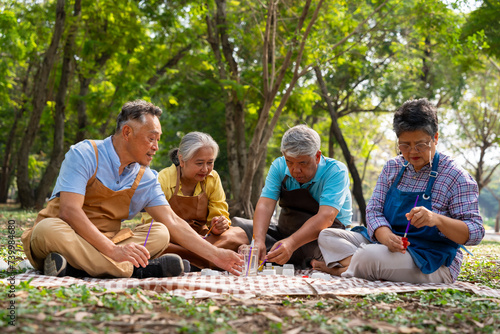 A group of Asian senior people enjoy painting cactus pots and recreational activity or therapy outdoors together  at an elderly healthcare center, Lifestyle concepts about seniority © Prot