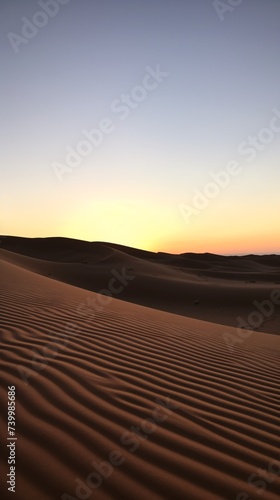 a sand dunes with a sunset in the background