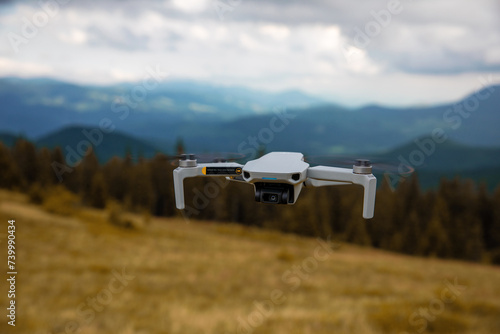 Obraz na płótnie Drone Hovering Above Vast Mountain Terrain Against Clear Blue Sky w salonie