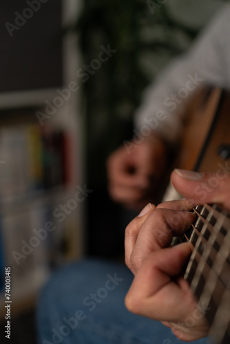 A closeup shot of a man's hand playing the guitar
