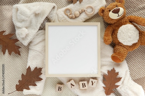 Pregnancy, baby coming announcement template, square wooden frame mockup, cozy fall flat lay composition with warm baby overalls, teddy bear toy, blanket, autumn leaves. photo
