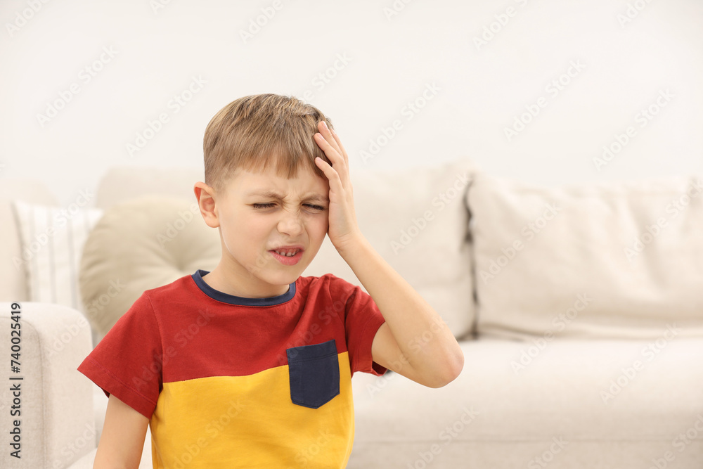 Little boy suffering from headache at home, space for text Little boy suffering from headache at home, space for text