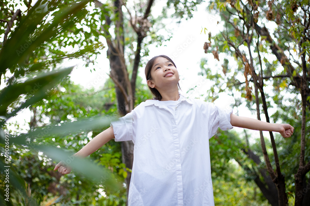 Asian girl breathing clean air in nature forest. Happy girl open arms in happiness. Fresh outdoor woods, wellness healthy lifestyle concept. Asian girl breathing clean air in nature forest. Happy girl open arms in happiness. Fresh outdoor woods, wellness healthy lifestyle concept.