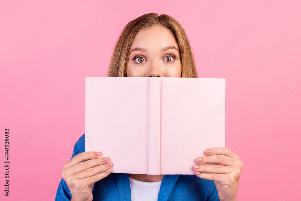 Photo of impressed funky lady dressed blue shirt enjoying interesting story hiding behind book isolated pink color background Photo of impressed funky lady dressed blue shirt enjoying interesting story hiding behind book isolated pink color background