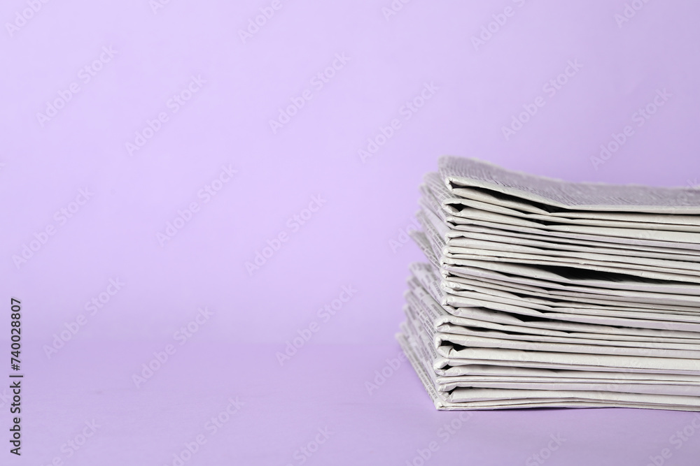 Stack of newspapers on light violet background, space for text. Journalist's work Stack of newspapers on light violet background, space for text. Journalist's work