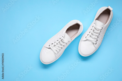 Wallpaper Mural Pair of stylish white sneakers on light blue background, top view. Space for text Torontodigital.ca
