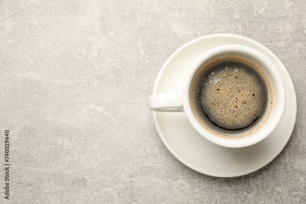 Cup of aromatic coffee on light grey table, top view. Space for text Cup of aromatic coffee on light grey table, top view. Space for text