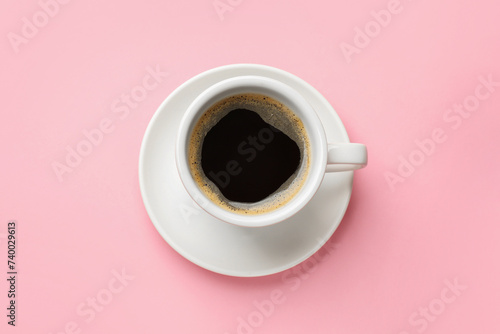 Fresh coffee in cup on pink background, top view
