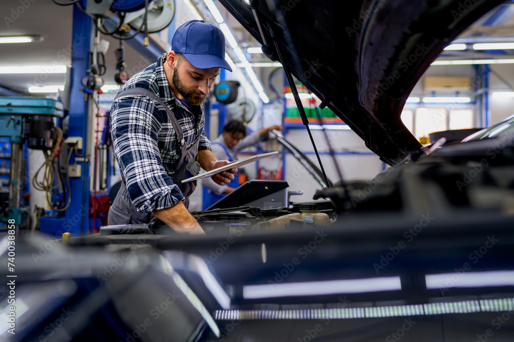 In the workshop, a mechanic utilizes a tablet for diagnostics and parts availability, seamlessly blending traditional expertise with modern technology. In the workshop, a mechanic utilizes a tablet for diagnostics and parts availability, seamlessly blending traditional expertise with modern technology.