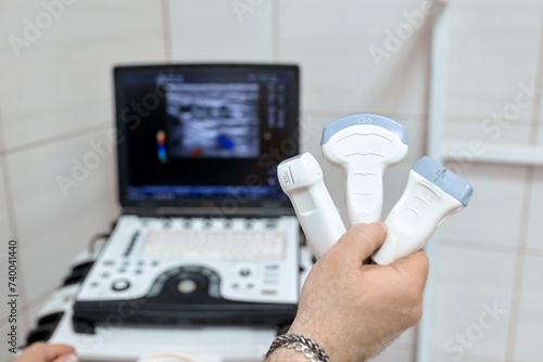 Close-up of ultrasound diagnostic probe. A doctor's hands hold a transducer for diagnosing internal organs using modern ultrasound technology, including elastography and sonography.