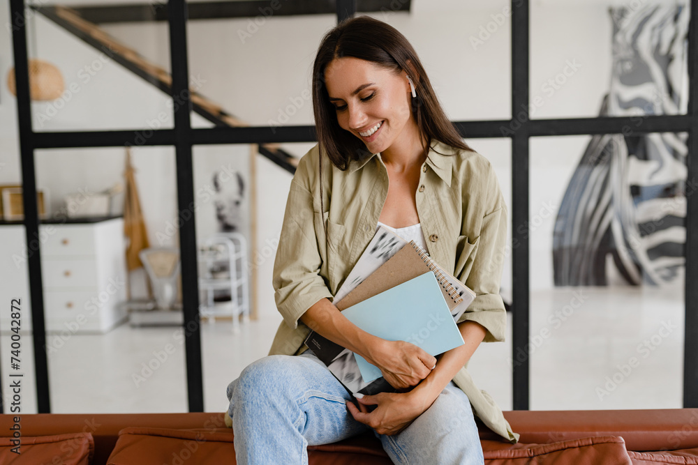 woman sitting on sofa at home relaxed dressed in khaki shirt and jeans woman sitting on sofa at home relaxed dressed in khaki shirt and jeans