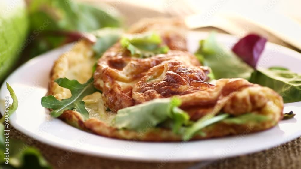 cooked fried omelets with zucchini and herbs on a wooden table. cooked fried omelets with zucchini and herbs on a wooden table.