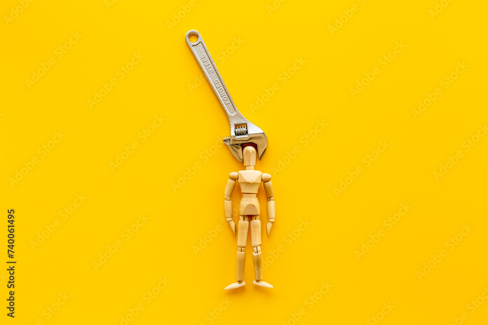 Head in pliers - headache and migraine concept. Wooden figurine of a man with pliers - obrazy, fototapety, plakaty 