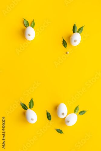 Easter eggs in shape of bunnies with spring green leaves and willow sprig. Easter festive layout