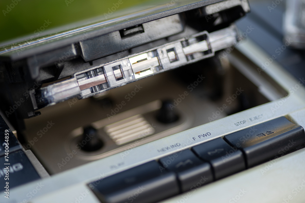 Close-up view of an old-fashioned cassette player with a cassette tape and its case. Close-up view of an old-fashioned cassette player with a cassette tape and its case.
