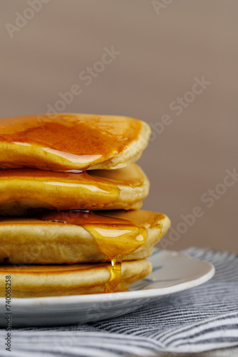 A stack of pancakes with honey on a vintage plate on the table. Breakfast. (ID: 740065258)