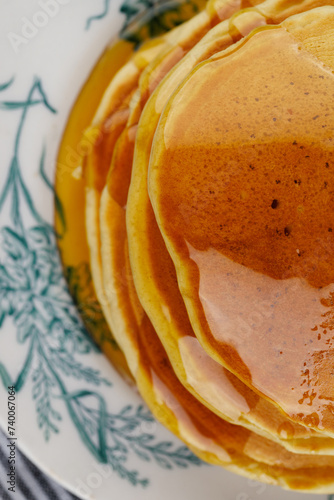 A stack of pancakes with honey on a vintage plate on the table. Breakfast. (ID: 740067064)