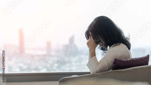 Anxiety disorder menopause woman with mental health illness, stressful depressed aging businesswoman female person with panic attack, headache and migraine sitting at home with city background © Chinnapong