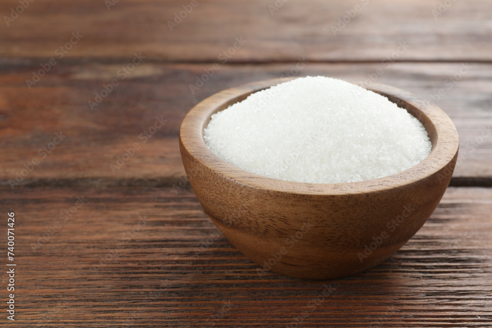Granulated sugar in bowl on wooden table, closeup. Space for text Granulated sugar in bowl on wooden table, closeup. Space for text