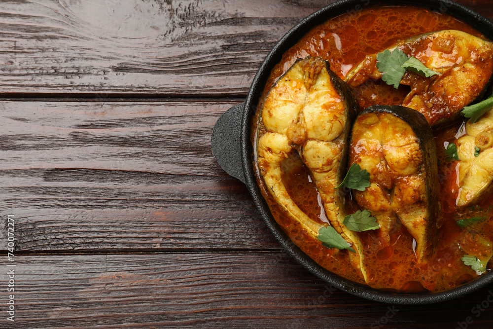 Tasty fish curry on wooden table, top view. Space for text. Indian cuisine Tasty fish curry on wooden table, top view. Space for text. Indian cuisine
