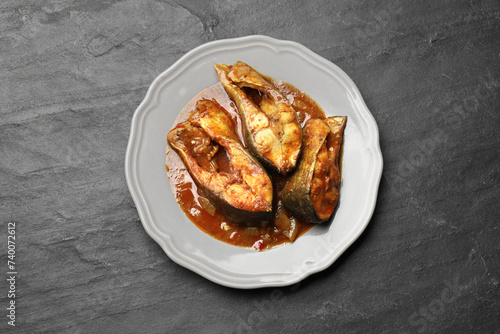 Tasty fish curry on grey textured table, top view. Indian cuisine photo