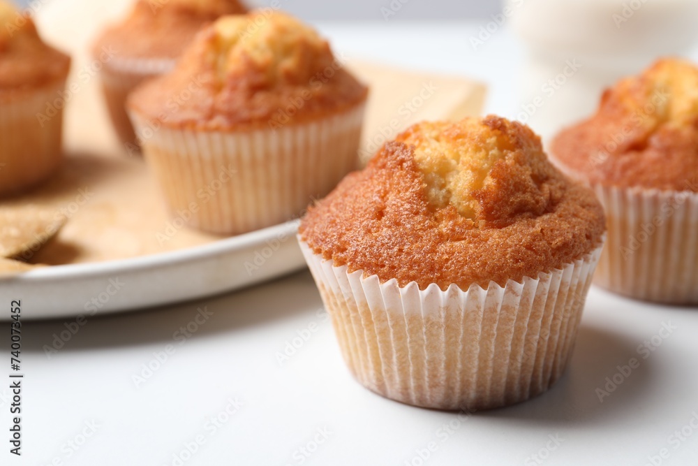 Delicious sweet muffins on white table, closeup. Space for text