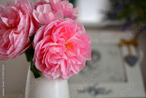 romantyczna rózowa roza w białym wazonie na stoliku, romantyczne tło, rózowa róza w wazonie, róza i ramka ze zdjęciem, romantic pink rose in a white vase on the table, romantic background 