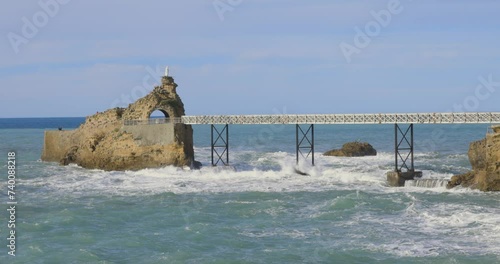 Establashing shot of rocher de la vierge in biarritz on the french coast of the atlantic ocean in the basque country photo