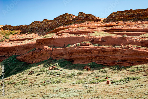 Layered red sandstone chugwater geological formation and cloudless blue sky in the desert landscape of Wyoming, USA photo