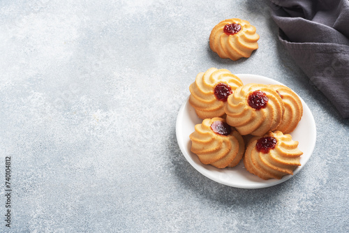 Kurabye shortbread cookies with berry jam in a plate. Delicious dessert, gray concrete background with copy space.