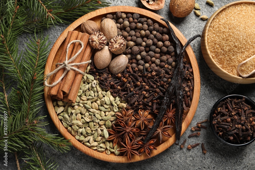 Different spices, nuts and fir branches on gray textured table, flat lay Different spices, nuts and fir branches on gray textured table, flat lay