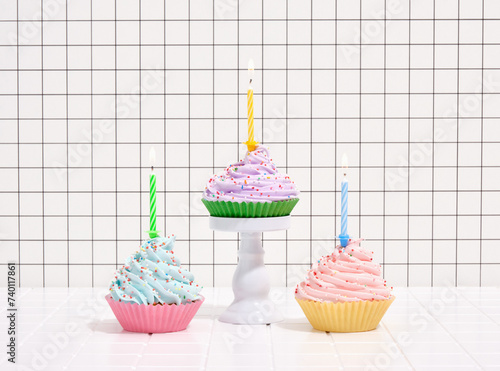 Cupcakes with colorful cream and sprinkles, festive candles. Concept of birthday party.