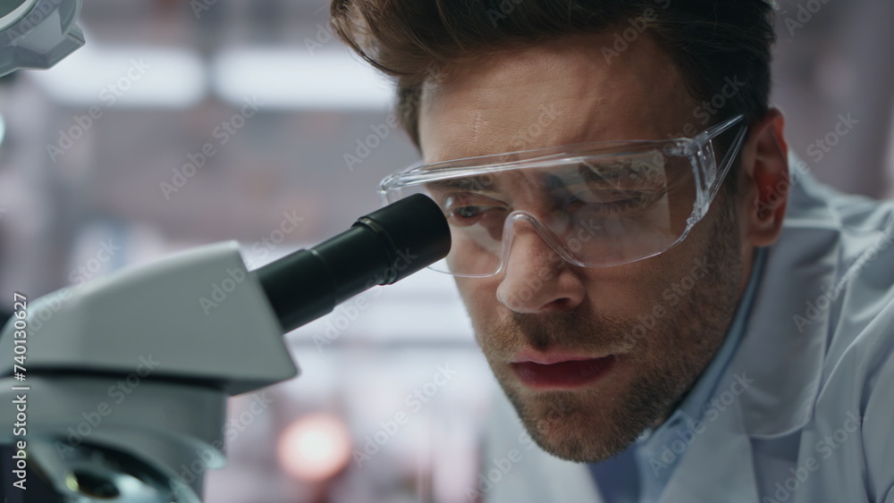 Pensive lab specialist working in genetics clinic closeup. Serious man scientist Pensive lab specialist working in genetics clinic closeup. Serious man scientist