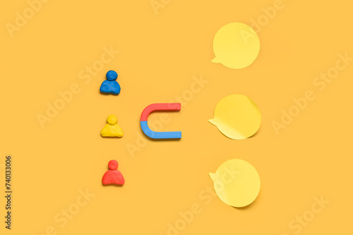 Fényképezés Magnet with group of customers and sticky notes on yellow background