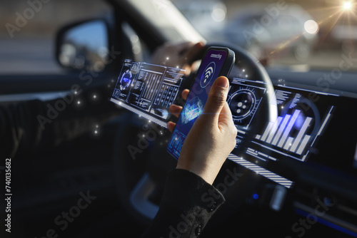 커넥티드카에서 스마트폰을 이용하여 연결중인 여성운전자의 손(홀로그램 합성) photo