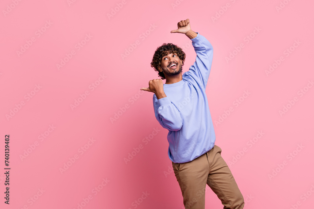 Photo portrait of attractive young man point interested banner empty space wear trendy blue clothes isolated on pink color background Photo portrait of attractive young man point interested banner empty space wear trendy blue clothes isolated on pink color background