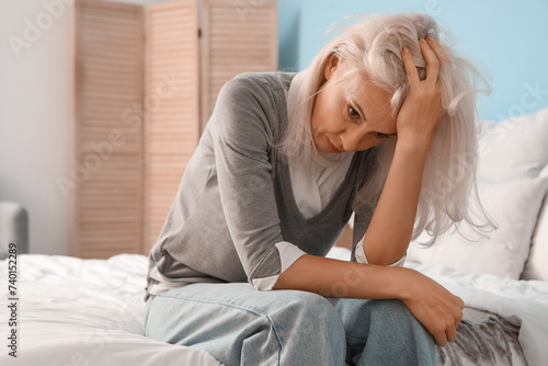 Depressed mature woman sitt...