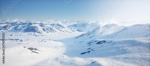 Arctic landscape with snow mountains under a clear blue sky.