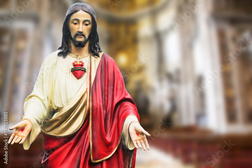Jesus statue background. Open arms Jesus Christ. Catholic religion statue. God son Jesus in red robe. Saint sculpture isolated on church interior background. Religious faith empty copy space.