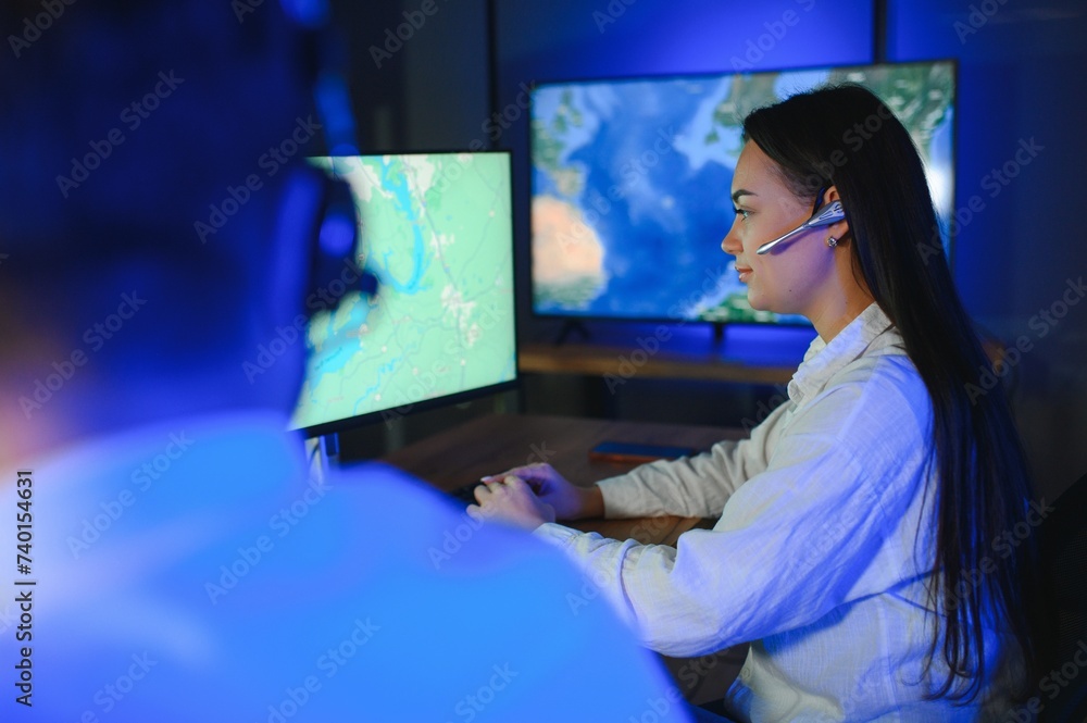 Smiling friendly female call center agent with headset working on support hotline in the office Smiling friendly female call center agent with headset working on support hotline in the office