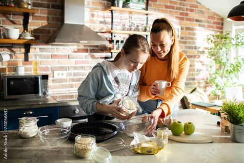 Mother and daughter baking together at home photo