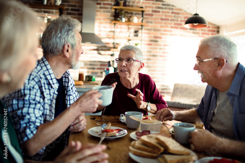 Group of senior friends enjoying conversation and breakfast together