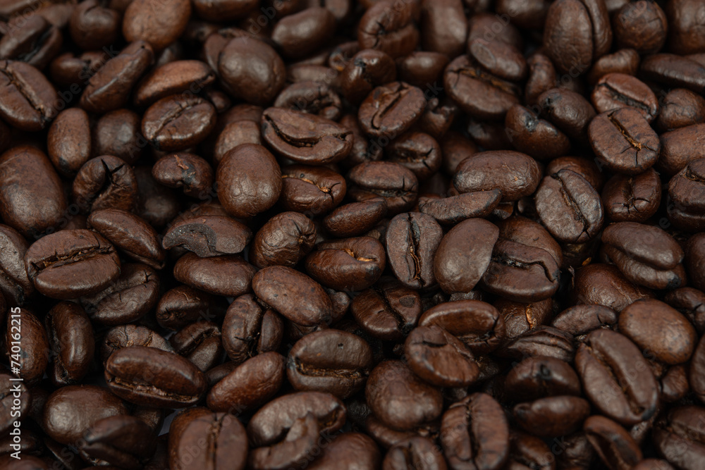 Fototapeta premium Coffee bean background. Roasted coffee beans on the entire surface. Brown coffee. Flat layout with top view.