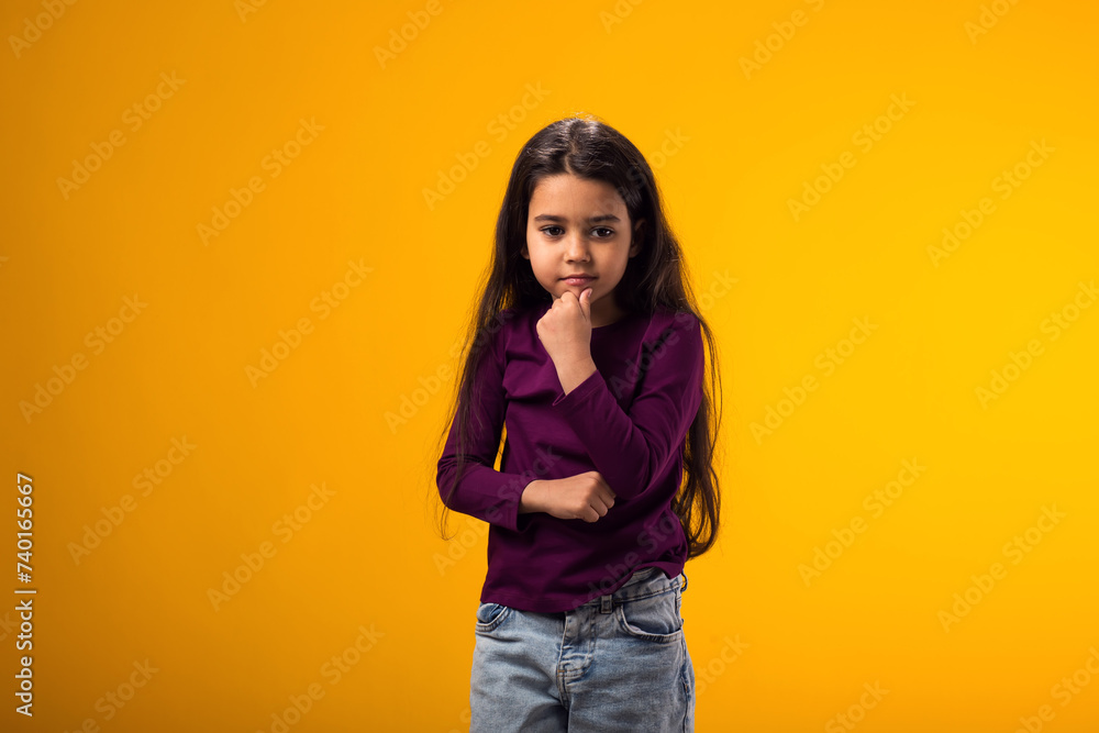 Thoughtful child girl touching chin with finger thinking or considering Thoughtful child girl touching chin with finger thinking or considering