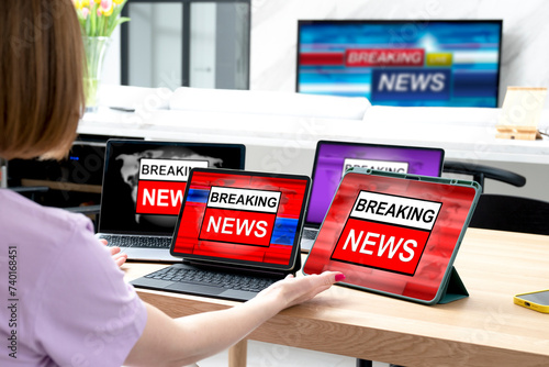 A woman watches breaking news on all her gadgets and TVs